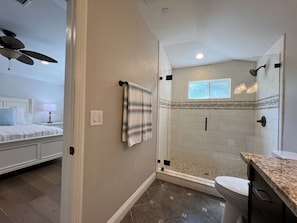 A bathroom with a shower, toilet, and a towel hanging on the wall. - Fantastic 6 bedroom, 4.5 bath home (4 master Suites), pool home (Anaheim)