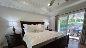 A bedroom with a large bed, two bedside tables, and a view of an outdoor patio. - Fantastic 6 bedroom, 4.5 bath home (4 master Suites), pool home (Anaheim)