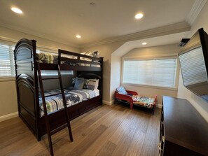 A room with a bunk bed, a single bed, a desk, and a window with blinds. - Fantastic 6 bedroom, 4.5 bath home (4 master Suites), pool home (Anaheim)