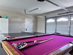 A pool table with a pink felt surface, a ping pong table, and a door in the background. - Incredible 5 Bedroom, 4 Bath, Rock Pool & Jacuzzi Home, 1/2 Mile Walk To Disney (Anaheim)