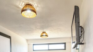 A compact room with a bunk bed, a small window, a chair, and a mounted TV. - Casa Arrecife| Tortuga: Wifi+ Cozy, Private bathroom, 1 room (La Ventana)