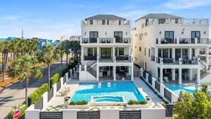 Un moderno edificio de dos pisos con piscina, balcones y vistas del entorno.