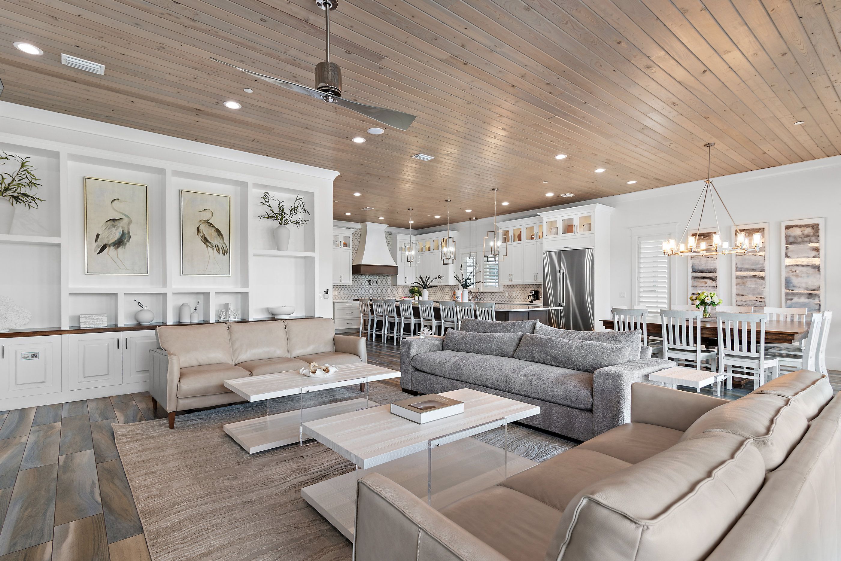 A modern living room with a sofa, coffee table, and a dining area with chairs and a table.