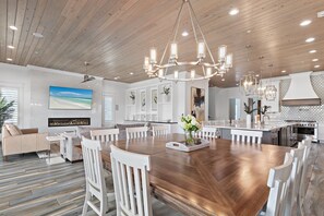 A spacious kitchen with a large island, modern appliances, and a wooden ceiling.