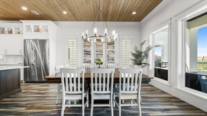 Una cocina moderna con una isla central, armarios blancos y un ventanal con vistas al exterior.