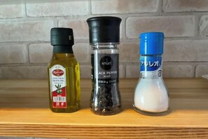 Tres botellas de condimentos en una estantería.