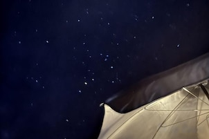 Cielo nocturno oscuro con estrellas visibles a través de una ventana.