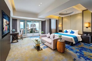 A hotel room with a bed, sofa, glass coffee table, and a view of the city. - LiSheng Yijia Hotel (Chengdu)