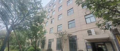 A multi-story building with a modern architectural design, featuring a series of windows and a central entrance.
