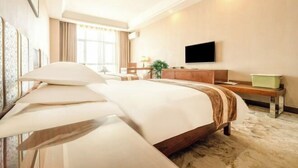 A hotel room with a large bed, a flat-screen TV, a wooden dresser, and a window with curtains. - Shuang Long Hotel (Gaotai)