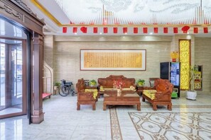 Una hall con reception, area salotto e un'ampia parete con calligrafia.