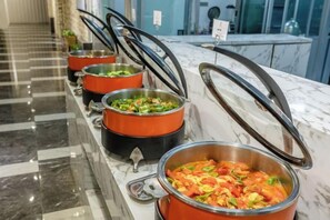 A buffet line with various food items in metal serving containers. - Shuang Long Hotel (Gaotai)