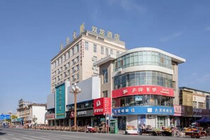 A hotel with a modern facade, multiple floors, and a prominent sign. - Shuang Long Hotel (Gaotai)