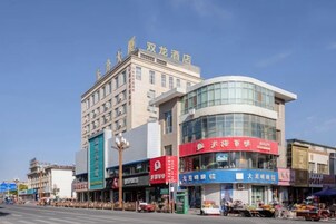 Un hotel con fachada moderna, varios pisos y un cartel llamativo.