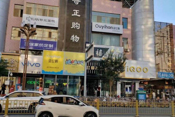 A commercial building with multiple storefronts, including a pharmacy and a technology store.