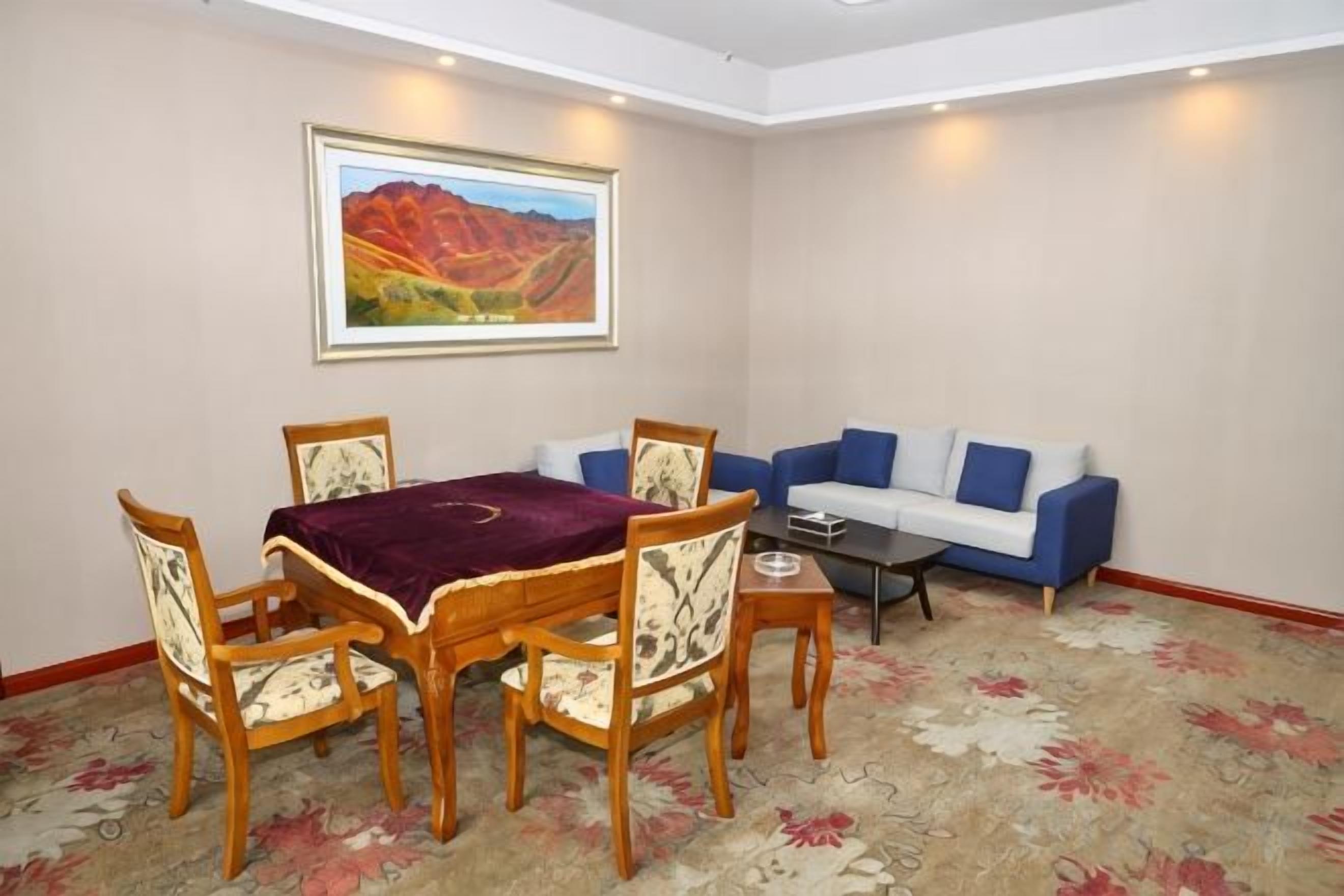 Un coin repas avec une table et des chaises, un canapé et un tableau accroché au mur.