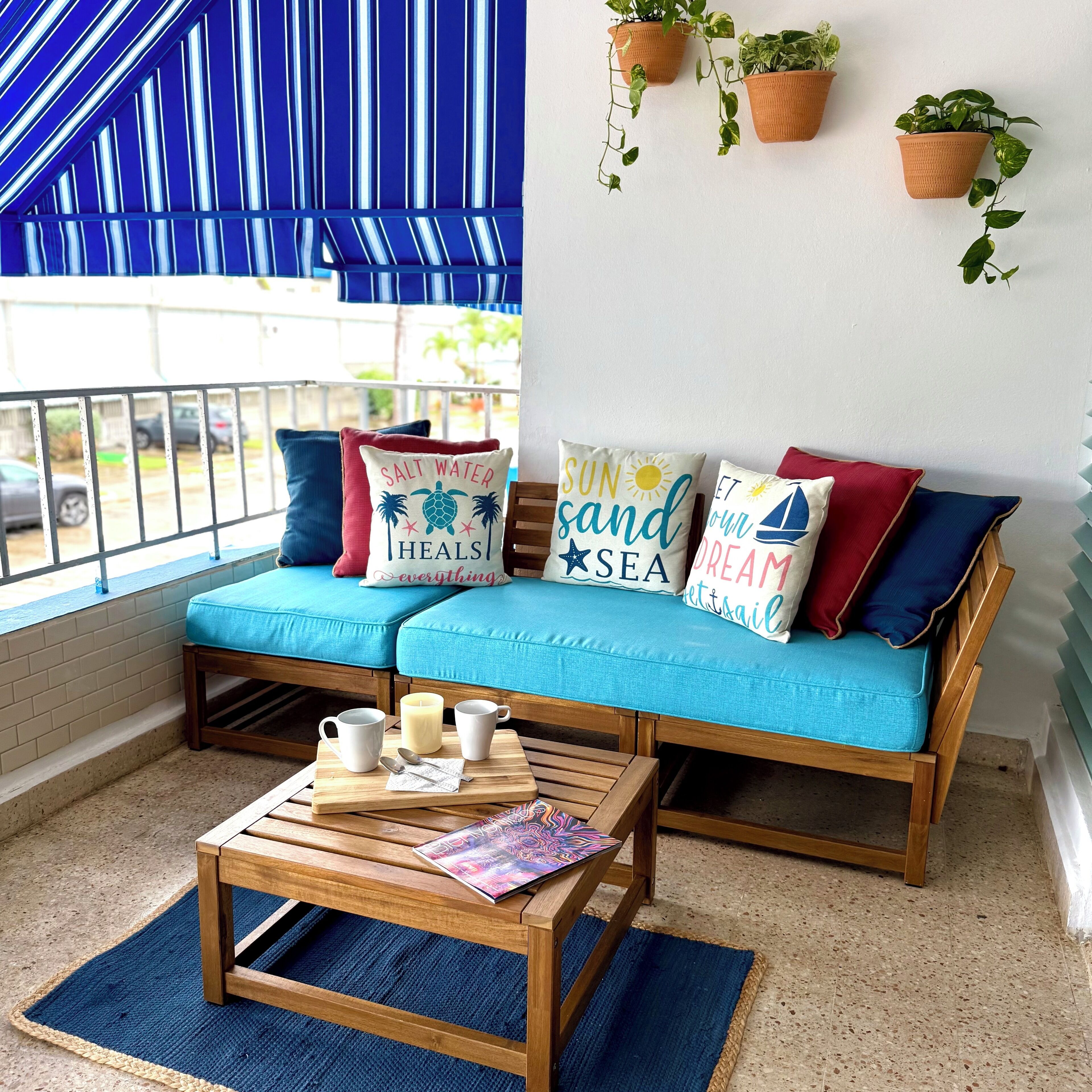 Un coin salon accueillant avec un canapé bleu, une table basse en bois et des coussins décoratifs.