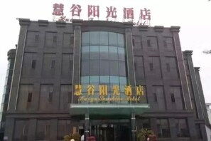 A hotel building with a large glass facade and signage in a foreign language.