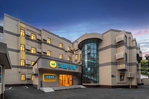 A multi-story building with a prominent entrance, large windows, and a curved glass facade. - HanTing Express Hotel (Shanghai Xinzhuang Subway Station) (Shanghai)