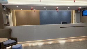 A reception area with a counter, seating, and a television screen.