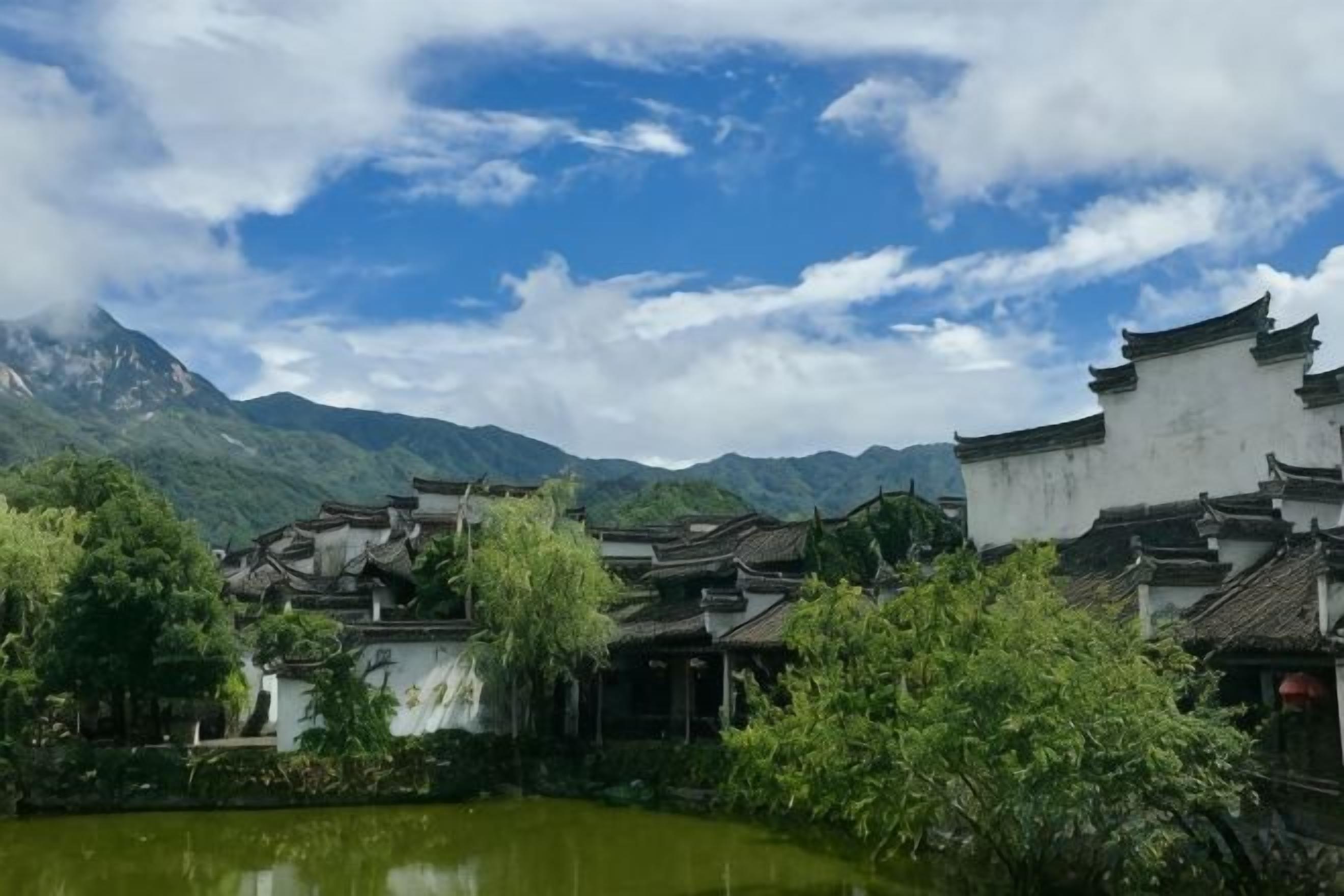 Traditional architecture with a courtyard and a mountain backdrop.