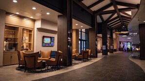 A lobby with a seating area, a television screen, and a gift shop.