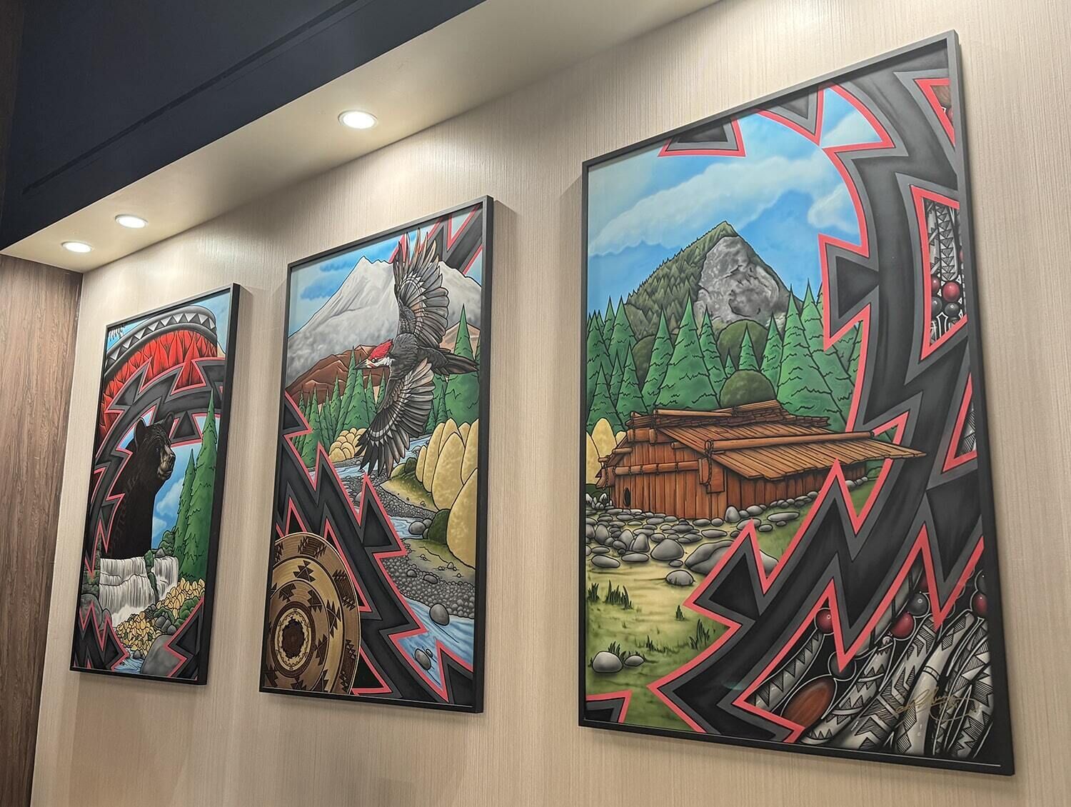 Trois œuvres d’art encadrées sont accrochées au mur.