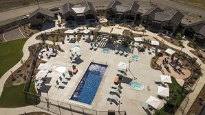 An aerial view of a resort with multiple swimming pools, lounge areas, and resort buildings.