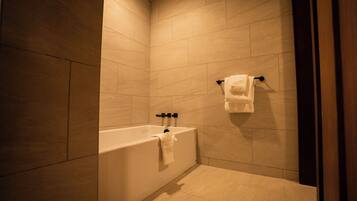 Un bagno moderno con una vasca, un portasciugamani e un water.