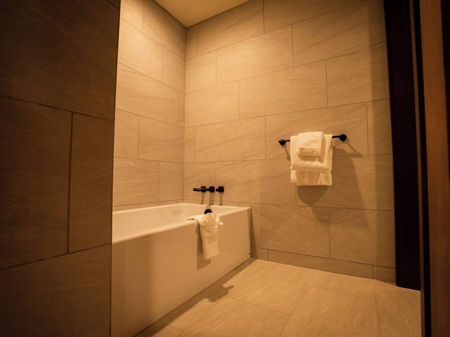 Un bagno moderno con una vasca, un portasciugamani e un water.