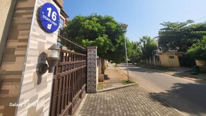 Una calle residencial con un cartel azul que indica el número 16.