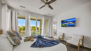 Une chambre dotée d’un grand lit, d’un ventilateur de plafond, d’une télévision et offrant une vue sur l’extérieur.
