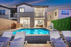 A two-story house with a swimming pool, lounge chairs, and a basketball hoop. - Lakefront new modern+ gameroom, next 2 golf+casino (Indio)