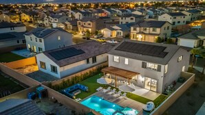 A modern two-story house with a swimming pool, outdoor seating, and a covered patio area. - 15 Bed, Glow Gameroom, Putting green, Pool & BBQ (Coachella)