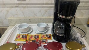 A kitchen counter with a coffee maker, sugar, cream, and milk containers, along with packets of instant coffee and creamer. - 4mins to Aso-Rock Villa, King Bed, Chef, Free Cleaning, 24/7 Electricity  (Abuja)