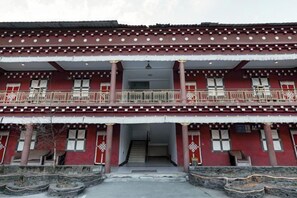 A two-story building with a balcony on the upper floor, a staircase leading to the entrance, and a traditional architectural style. - Garze Tagong Grassland Hotel (Kangding)
