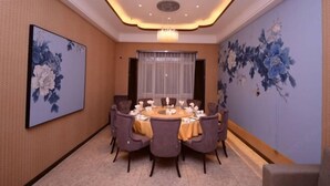 Ein Konferenzraum mit rundem Tisch, Stühlen und einer Chandelier.