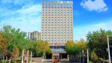 A tall hotel building with a modern facade and a clear sky.