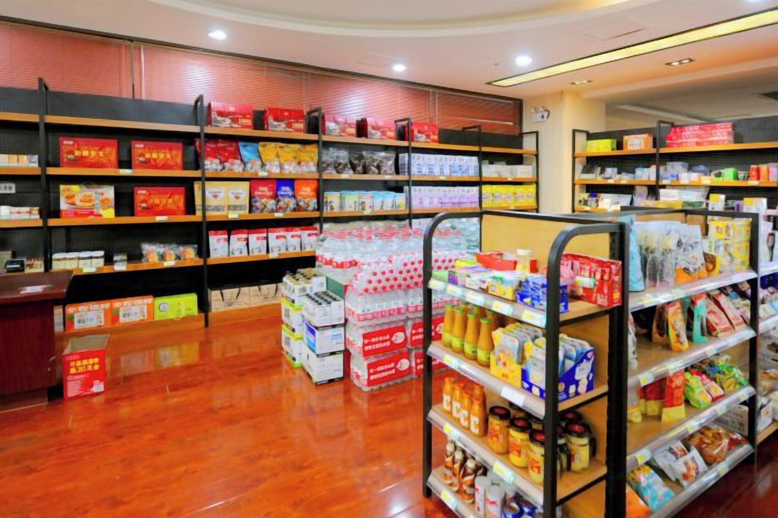 A store interior with shelves stocked with various products, a checkout counter, and a display of bottled water.