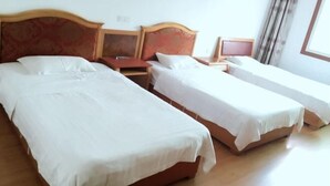 A hotel room with two beds, wooden headboards, and a window with curtains. - Changning Xiuyuan Hotel (Changning)