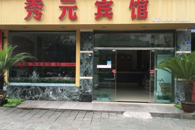 L'ingresso di un hotel con una porta in vetro e un cartello sopra.