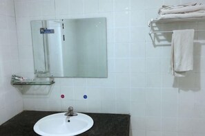A bathroom with a white sink, a mirror, and a towel rack. - Changning Xiuyuan Hotel (Changning)