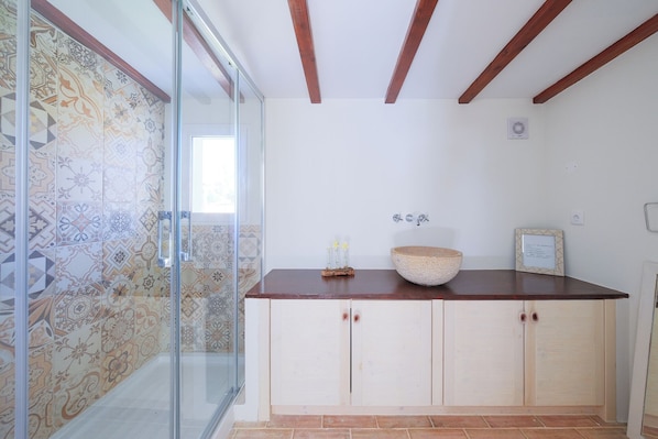 A bathroom with a glass shower enclosure, a wooden countertop, a ceramic sink basin, and a tiled backsplash. - Monte das Estrelas (Tavira)