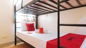 A bunk bed room with a white mattress, red pillows, and a red blanket. - RedDoorz @ Golden Travellers Inn Antique (San Jose de Buenavista)