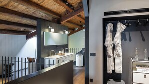 Un baño moderno con un espejo grande, lavamanos dobles y un mueble de tocador con espacio de almacenamiento.