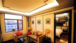 Una habitación de hotel moderna con sofá, mesa de centro, lámpara y cama.