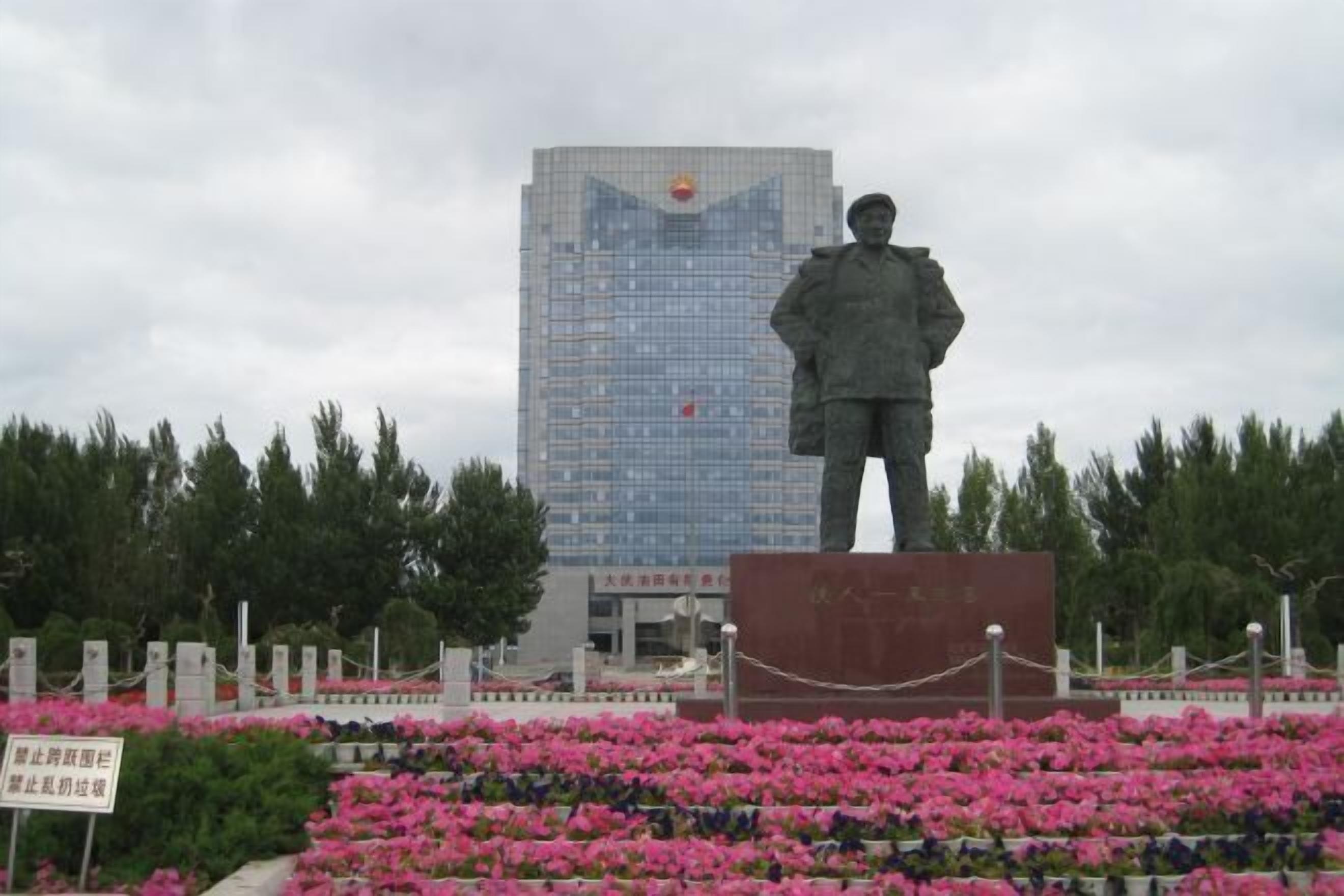 A statue of a soldier in front of a building with a red emblem.