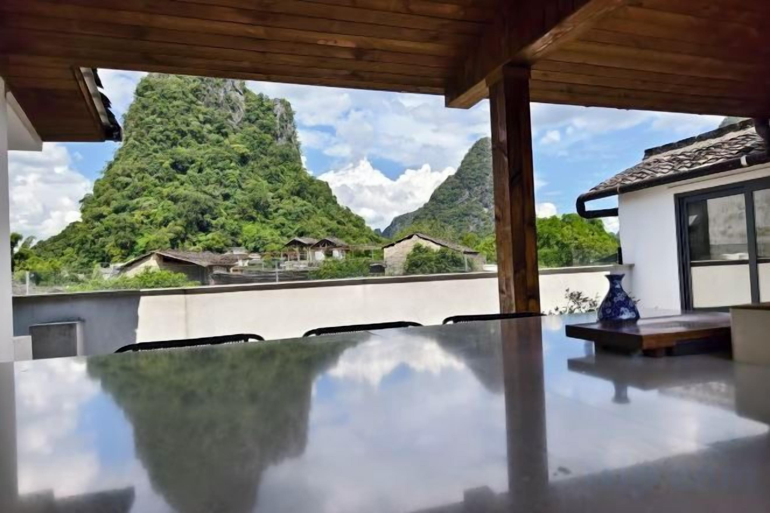 A dining area with a view of a mountain and traditional buildings.