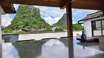 A dining area with a view of a mountain and traditional buildings.