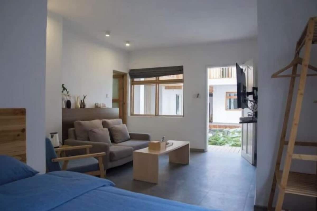 Una habitación moderna con sofá, cama, mesa de centro y televisor.